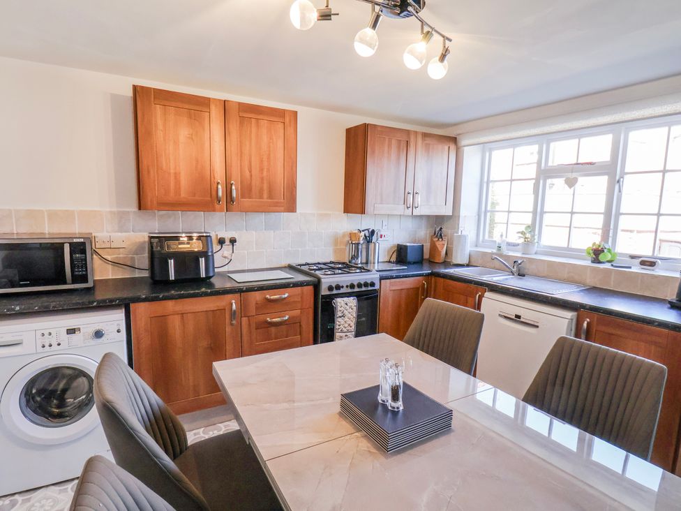 A kitchen with appliances and dining table at 1 West Ville Mews in York