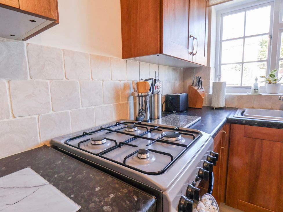 A kitchen with a gas stove and kitchen cabinets at 1 West Ville Mews York