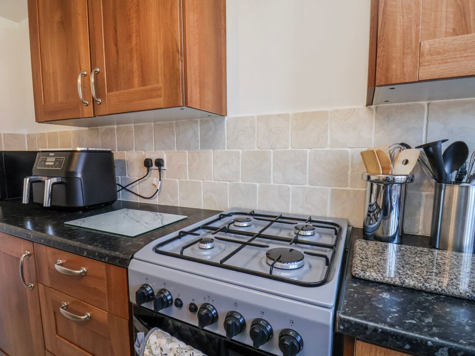 A kitchen featuring a gas stove and countertop appliances at 1 West Ville Mews York