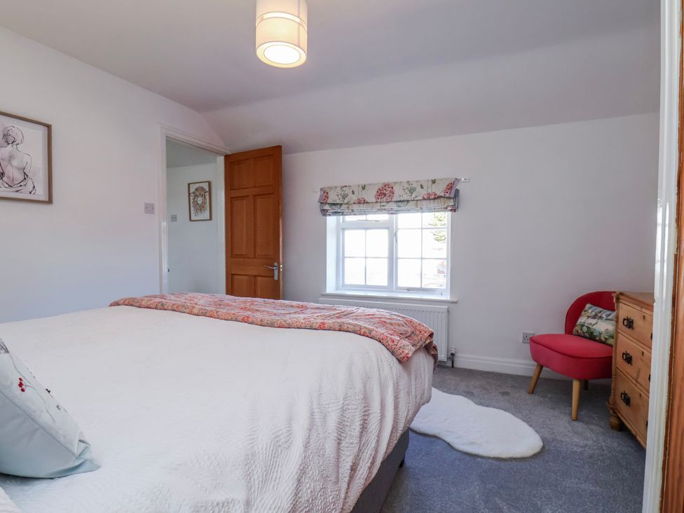 A bedroom with a bed and armchair at 1 West Ville Mews York
