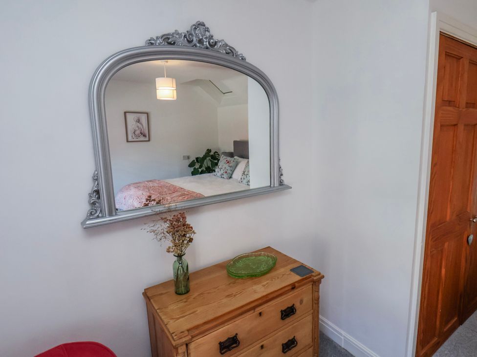 A bedroom with a mirror reflecting bedding and a cabinet at 1 West Ville Mews in York