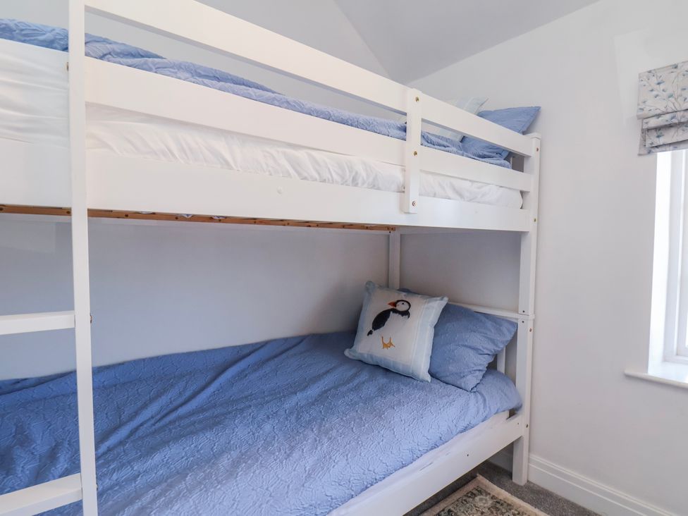 A bunk bed with blue bedding and a pillow in a bedroom at 1 West Ville Mews in York
