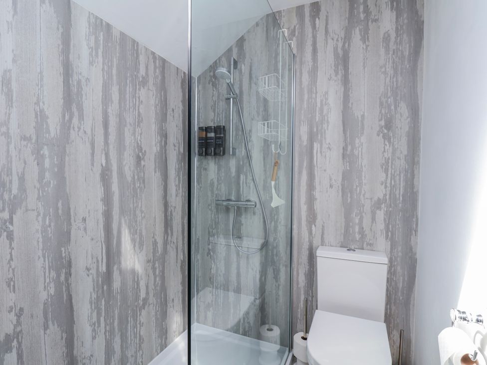 A shower with glass enclosure and a toilet at 1 West Ville Mews York