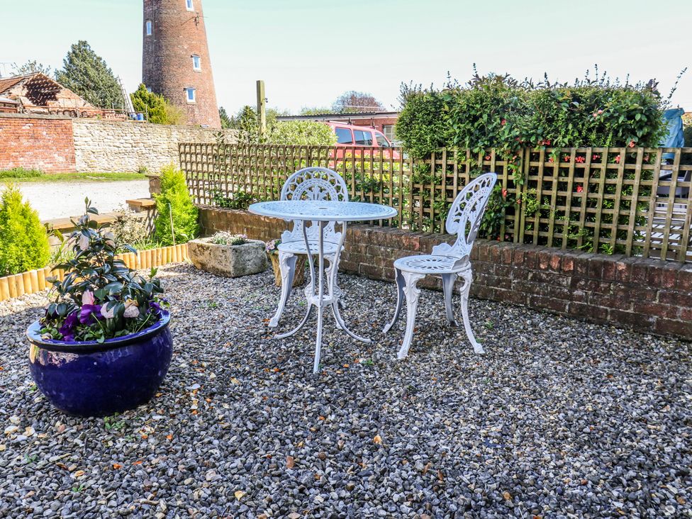 A garden with a table, chairs, and a plant pot at 1 West Ville Mews in York