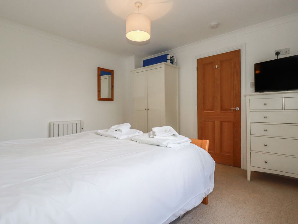 A bedroom with a bed and wardrobe at Stowaway Cottage in Padstow