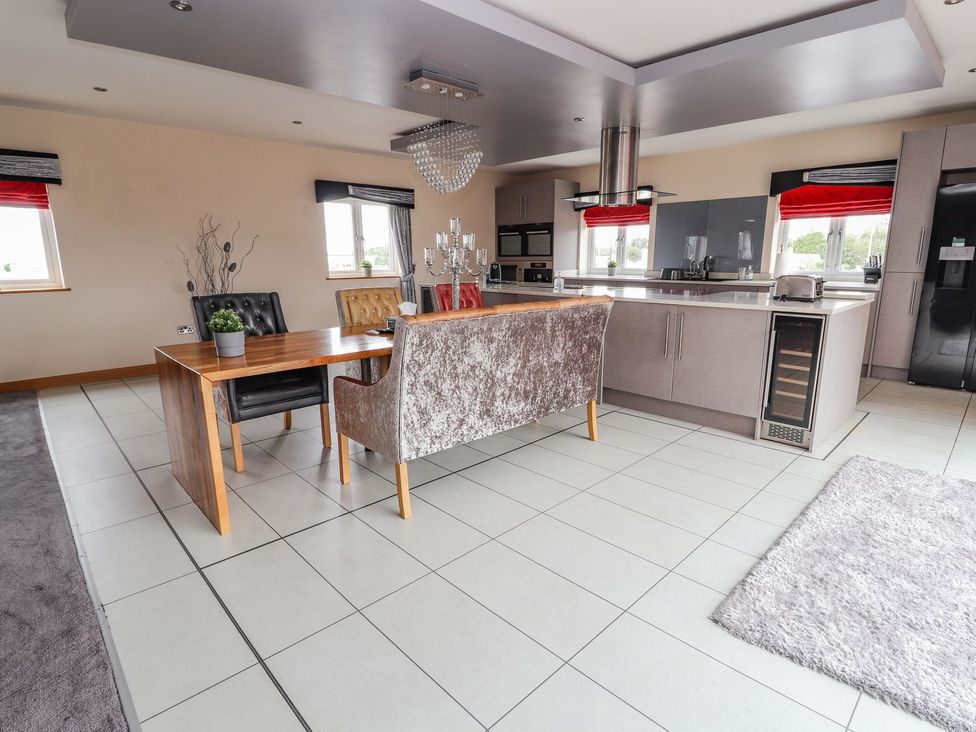A kitchen with a dining table and chairs at The Wendover in Abergele
