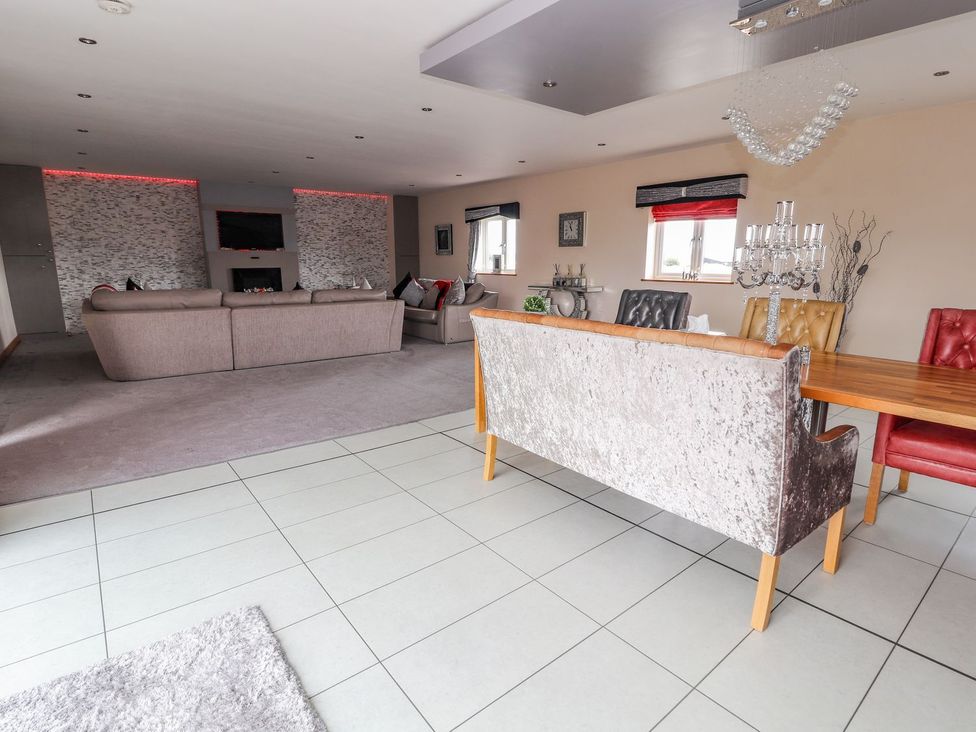 A living room with a sofa and dining area at The Wendover in Abergele