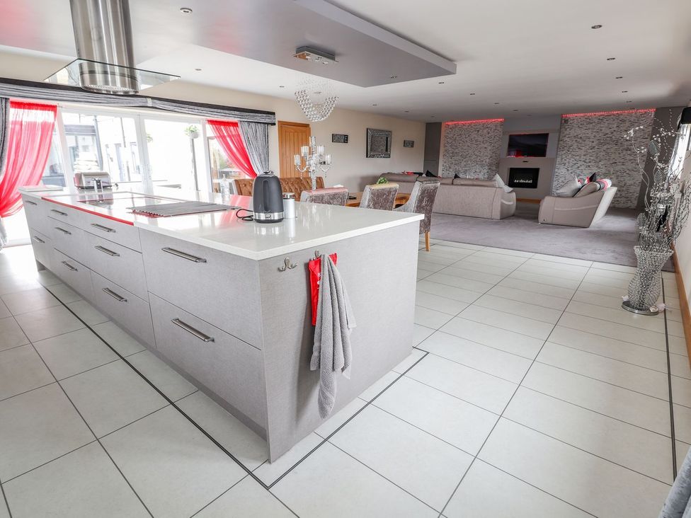 An open plan living space with a kitchen island and seating area at The Wendover in Abergele