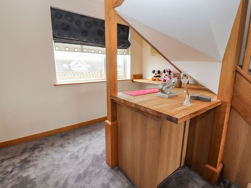 A landing area with wooden table and window at The Wendover in Abergele