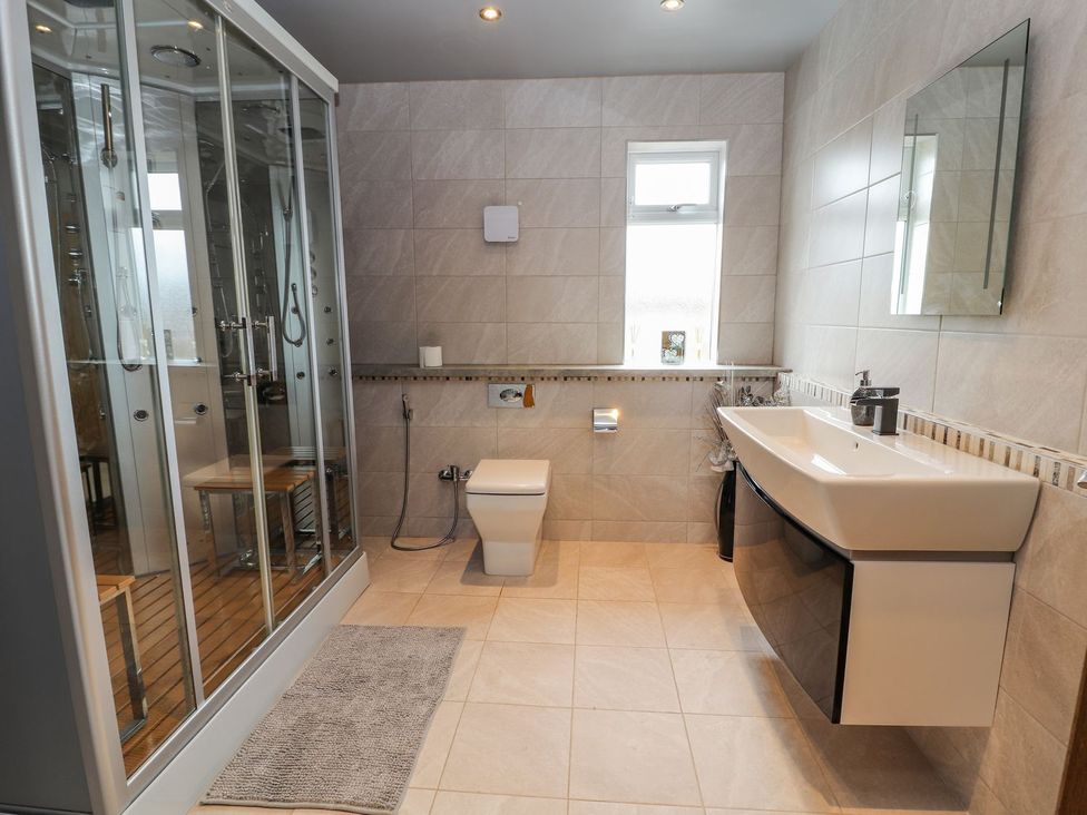 A bathroom featuring a shower, toilet, and sink at The Wendover in Abergele