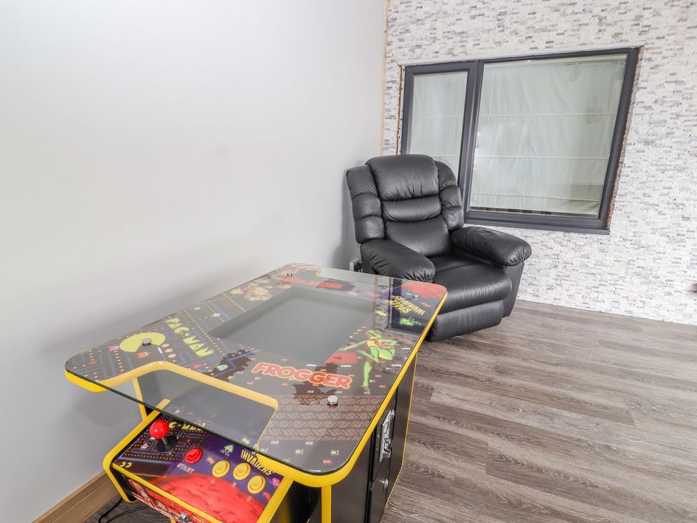 A game room with an arcade table and a recliner chair at The Wendover in Abergele