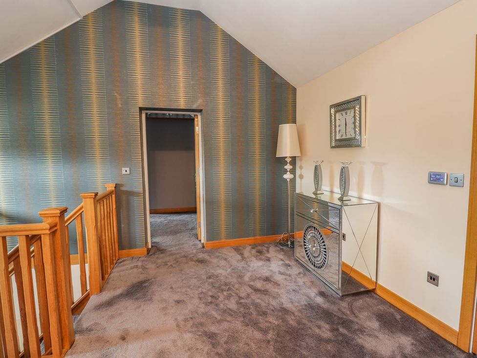 A landing with a lamp and mirror at The Wendover in Abergele