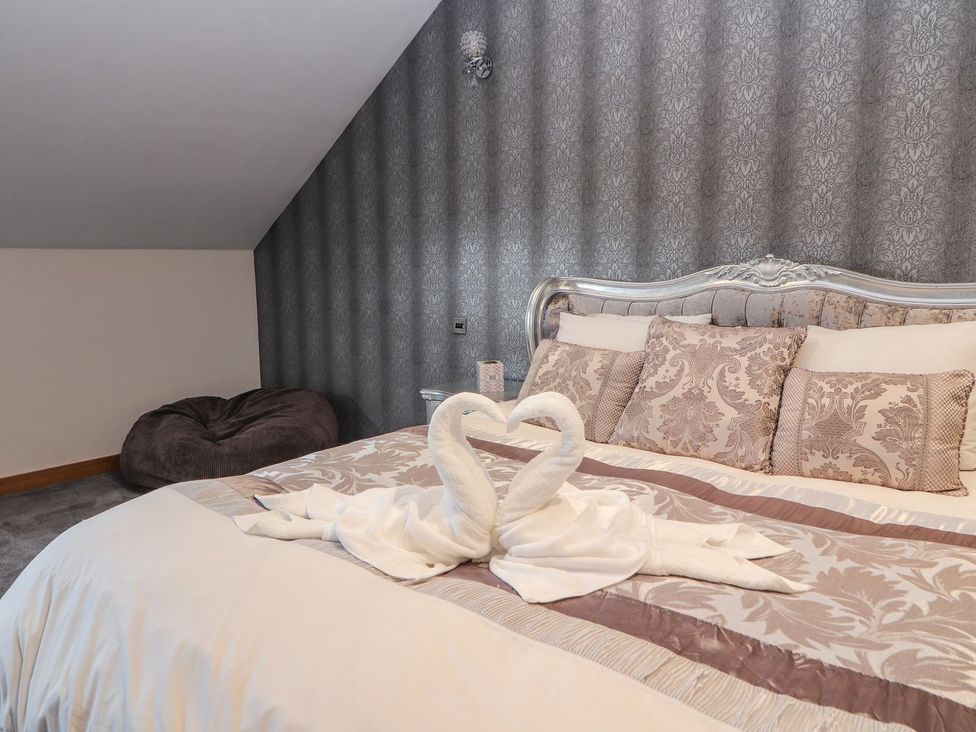 A bedroom with a bed and towels shaped like swans at The Wendover in Abergele