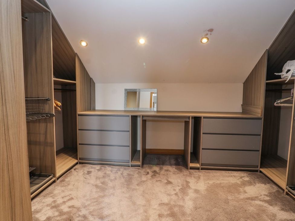 A dressing room with a mirror and storage units at The Wendover in Abergele