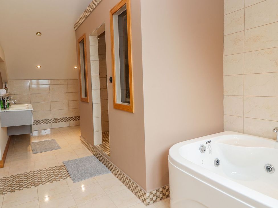 A bathroom with a bathtub, shower and sink at The Wendover in Abergele