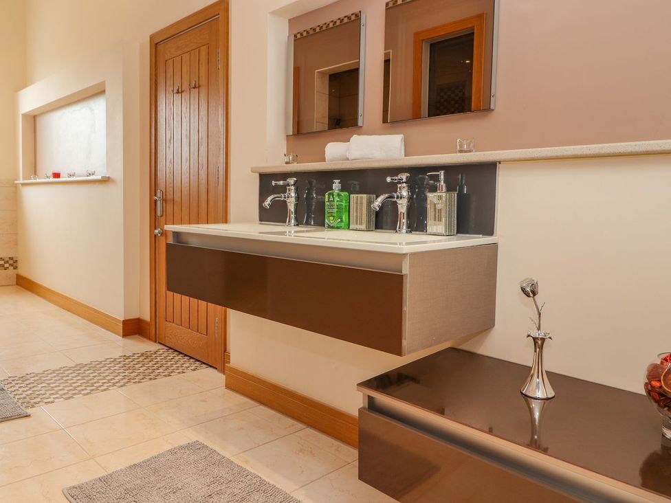 A bathroom with a sink and mirrors at The Wendover in Abergele