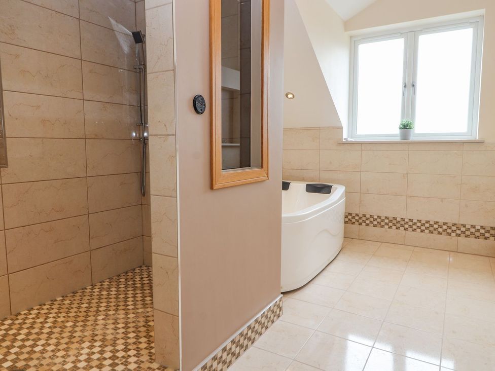 A bathroom with a shower and a bathtub at The Wendover in Abergele