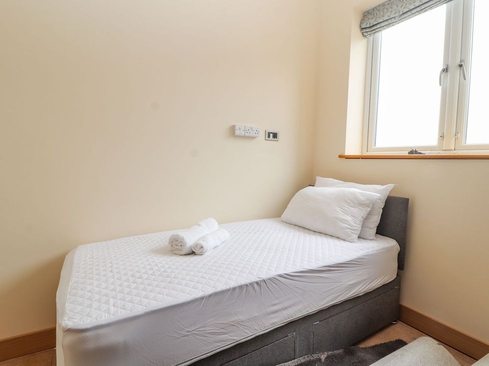 A bedroom with a bed and towels at The Wendover in Abergele