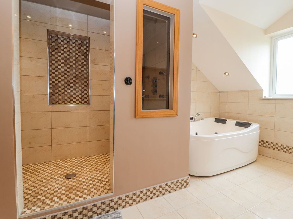 A bathroom with a shower and a bathtub at The Wendover in Abergele