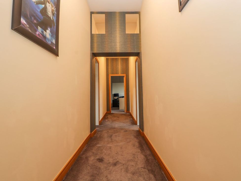 A hallway with carpet leading to a room at The Wendover in Abergele