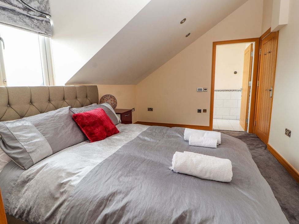 A bedroom with a bed and towels at The Wendover in Abergele