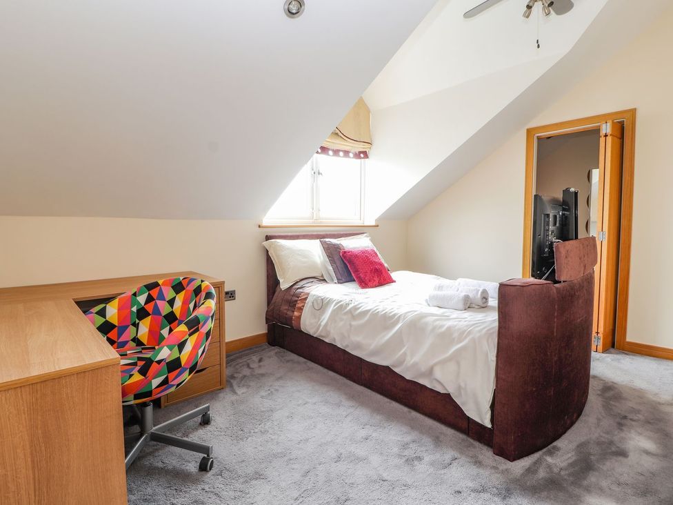 A bedroom with a bed and desk at The Wendover Abergele