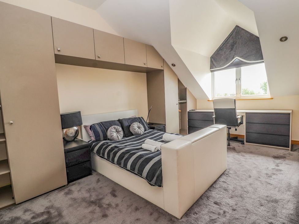 A bedroom with a bed and a desk at The Wendover in Abergele