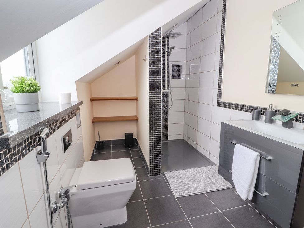 A bathroom with a shower, toilet and sink at The Wendover in Abergele