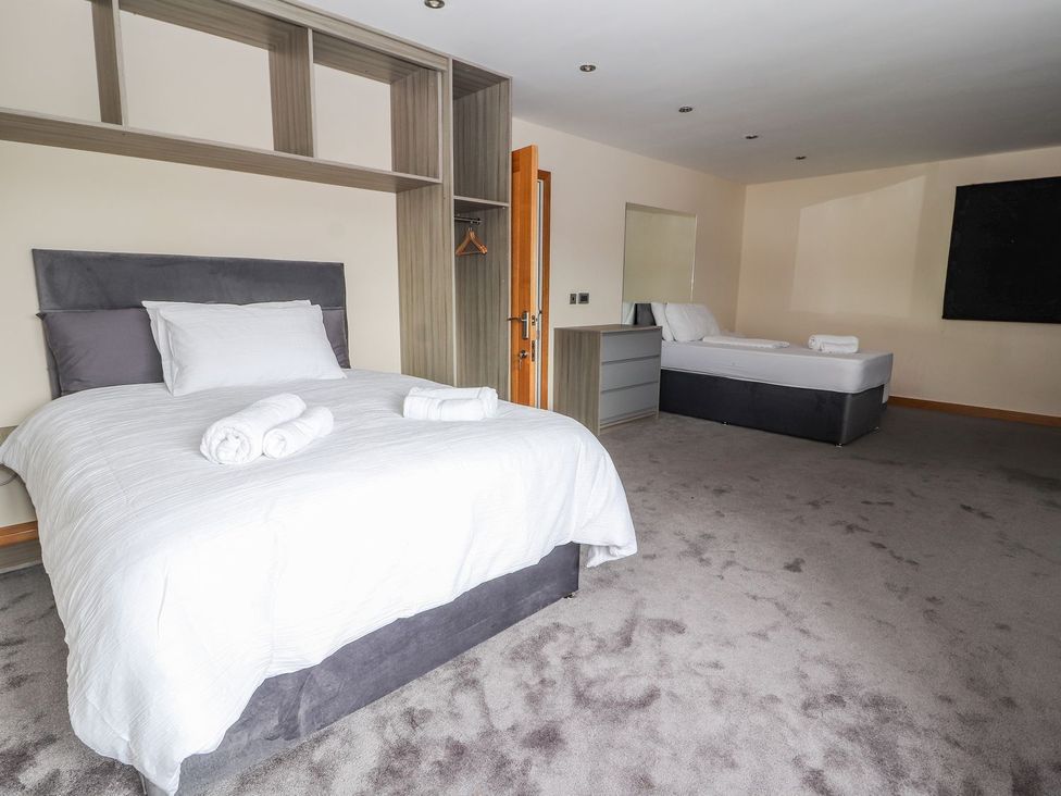 A bedroom with two beds and furniture at The Wendover in Abergele
