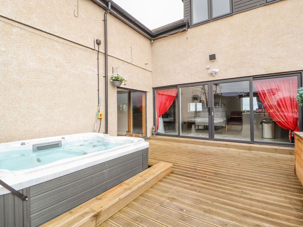 An outdoor area with a hot tub and sliding doors at The Wendover in Abergele
