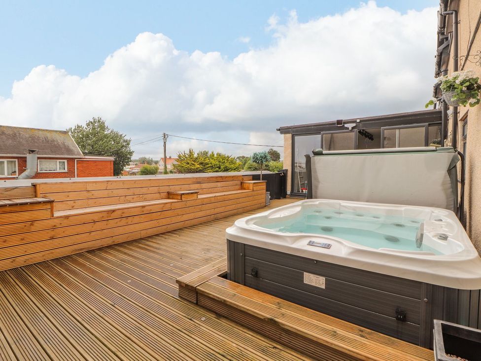 An outdoor space with a hot tub and wooden decking at The Wendover in Abergele