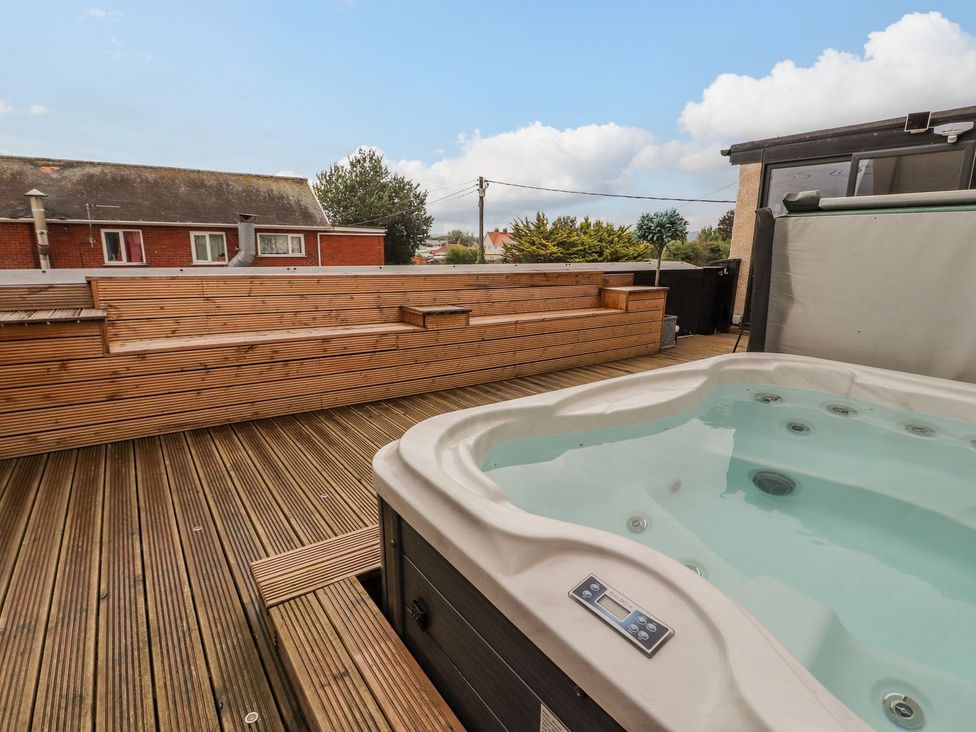 An outdoor area with a hot tub and wooden benches at The Wendover in Abergele