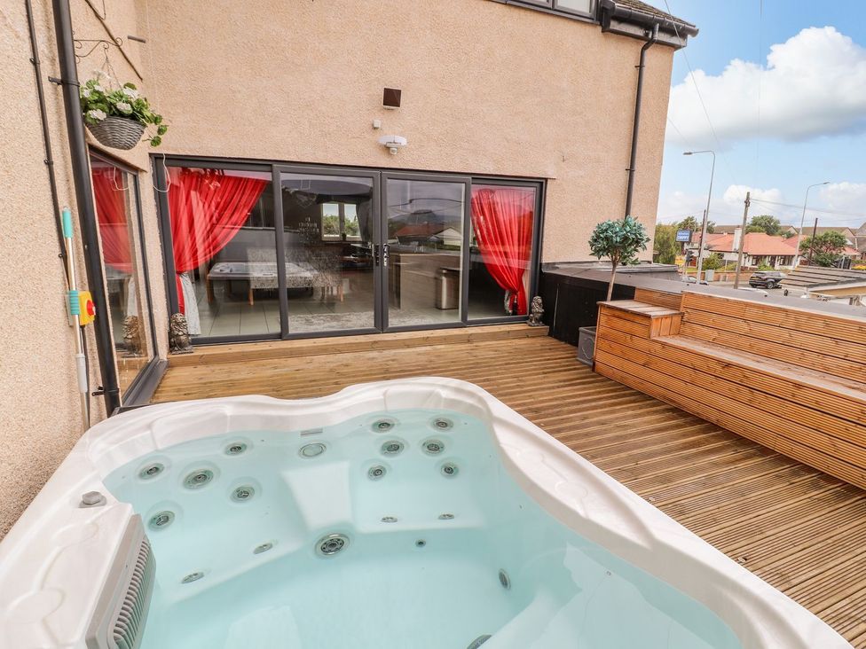 An outdoor area with a hot tub and wooden deck at The Wendover in Abergele