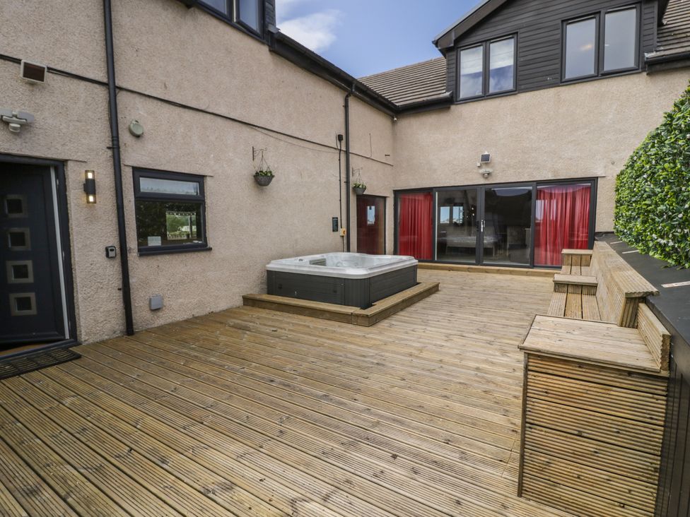 An outdoor area with a hot tub and seating at The Wendover in Towyn