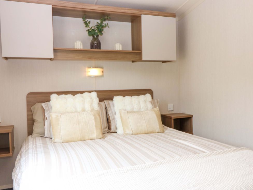A bedroom with a bed and shelf at 18 Eden Heights in St Andrews