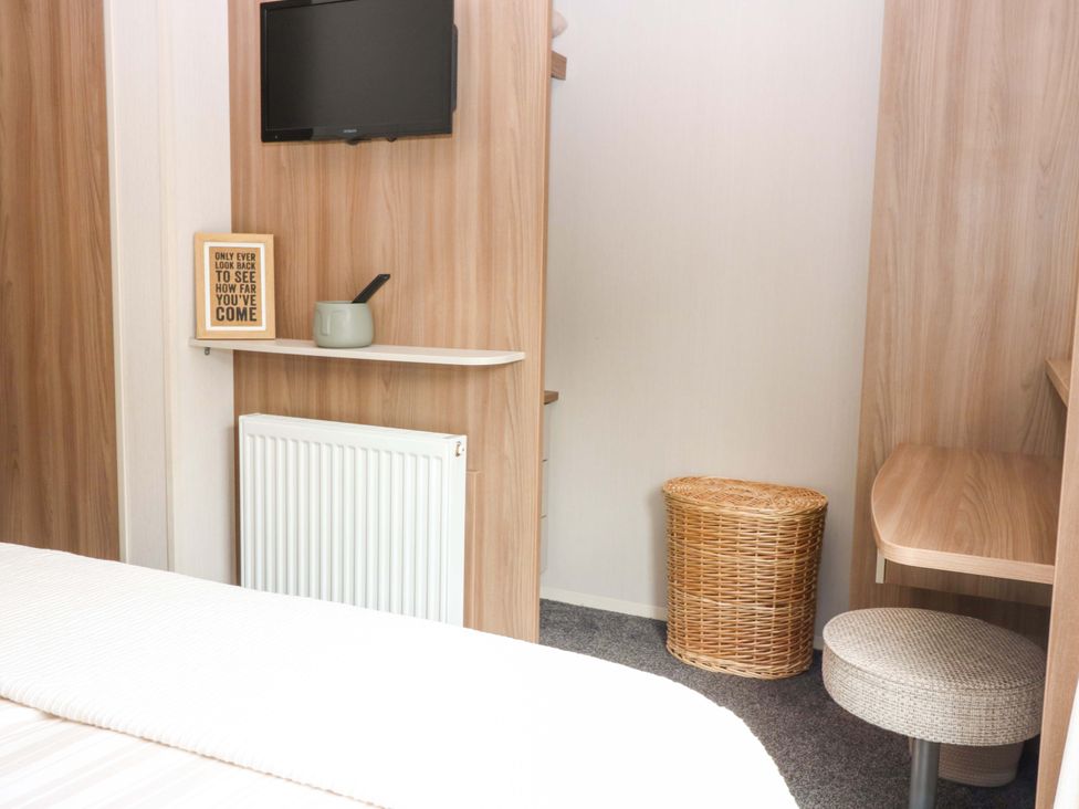 A bedroom with a television and shelf at 18 Eden Heights in St Andrews