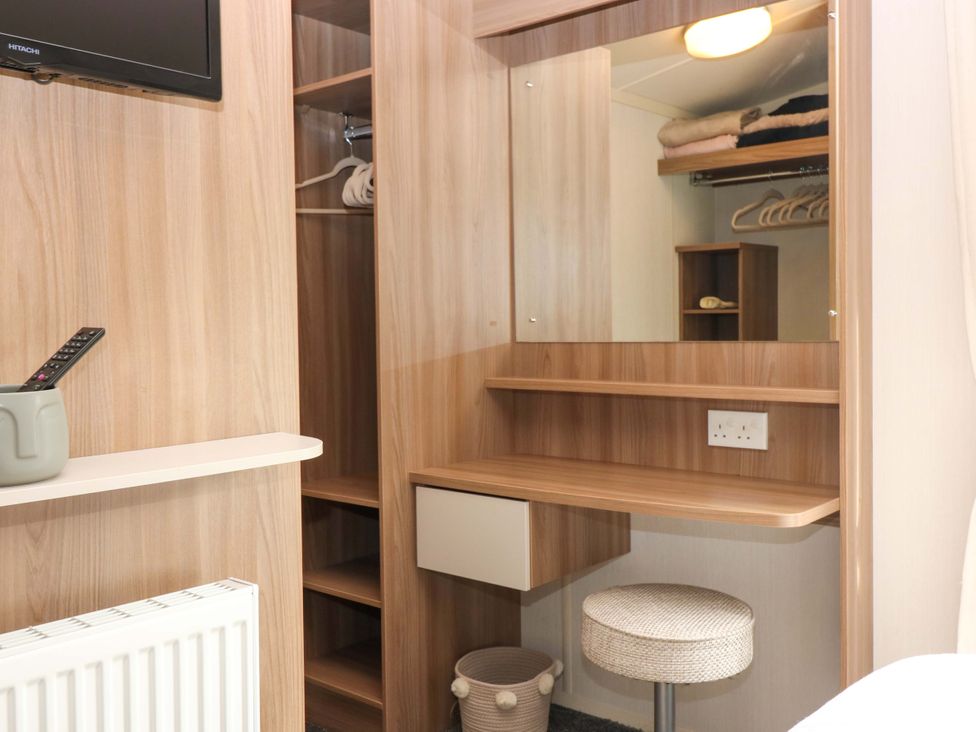 A bedroom with a desk, mirror, and television at 18 Eden Heights St Andrews