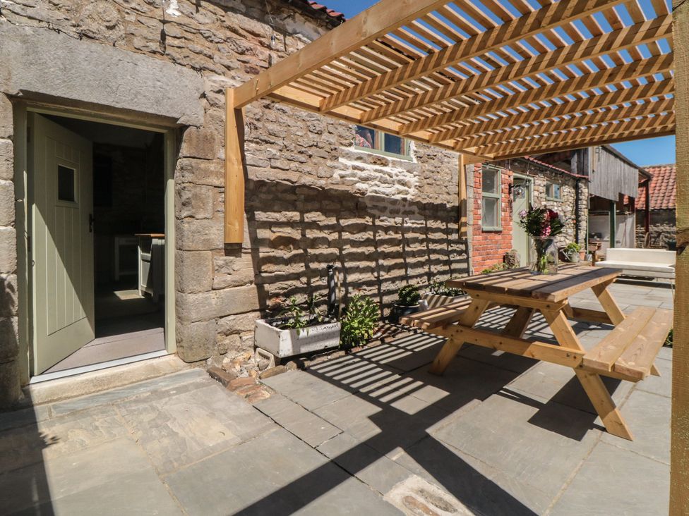 An outdoor area with a table and benches under a pergola at 1 bed in York