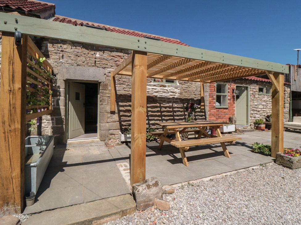 An outdoor area with a table under a pergola at 1 bed in York