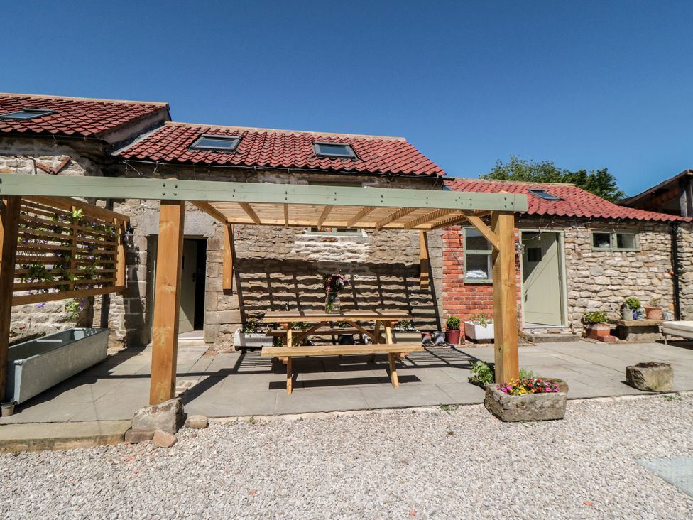 A garden area with a table and benches under a pergola at 1 bed in York