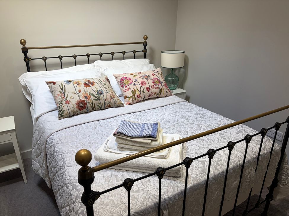 A bedroom with a bed and pillows at The Cottage at Thorpe Farm in Appleton-le-Moors near Kirkbymoorside
