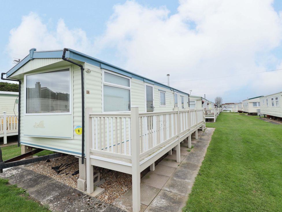 A static caravan with decking and grass area at Number 9 in Skegness
