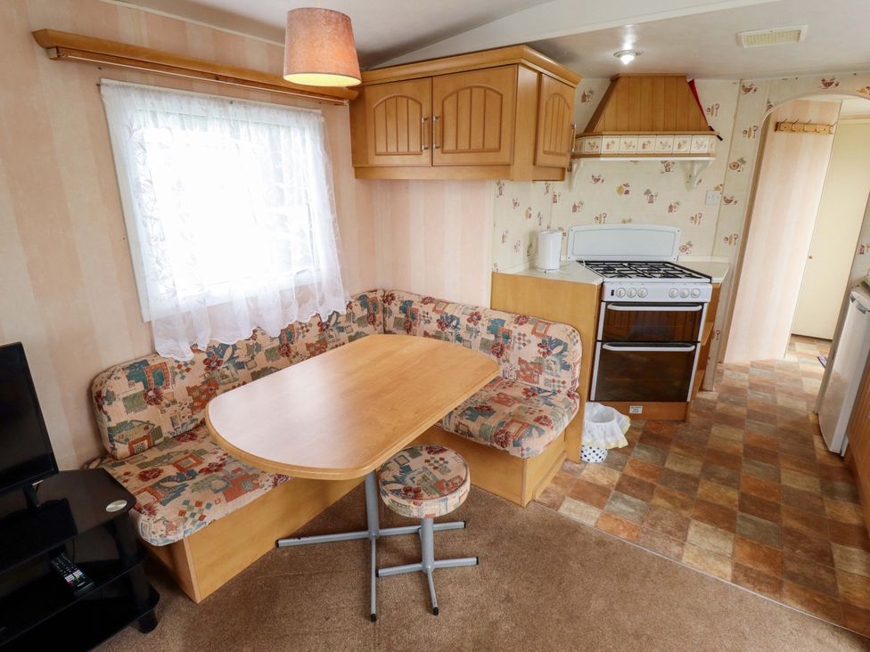 A kitchen with a table and benches at Number 9 in Skegness