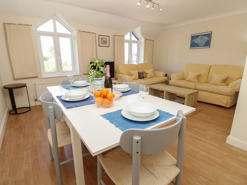 A dining room with a table set for a meal and sofas at Anchorage House Seaview