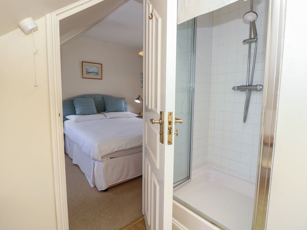 A bedroom with a bed and adjoining shower at Anchorage House Seaview
