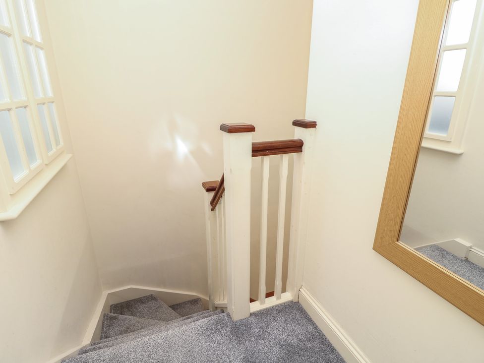 A staircase with a handrail and mirror at Anchorage House Seaview