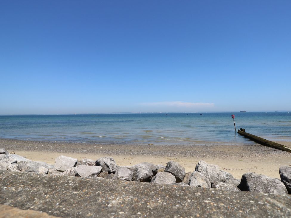 A beach with water and a pier at Anchorage House Seaview