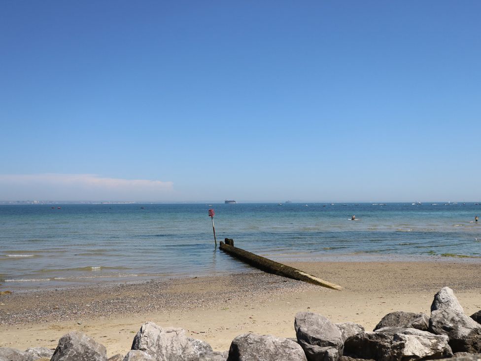 A beach with a pier and boats in the water at Anchorage House Seaview