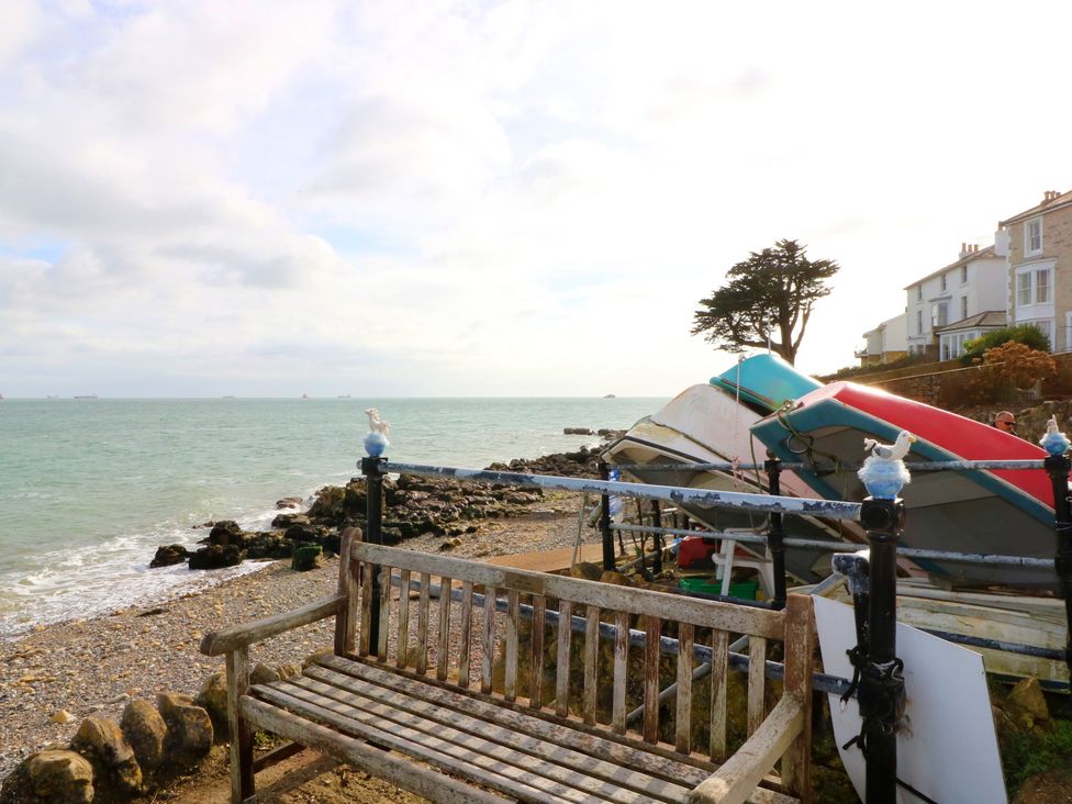 A bench near boats on the shore at Anchorage House in Seaview
