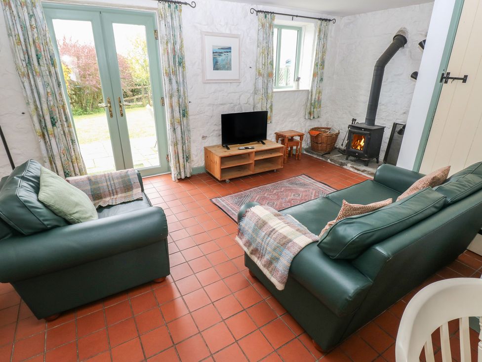 A living room with a TV and a fireplace at Swallow Cottage in Cowbridge